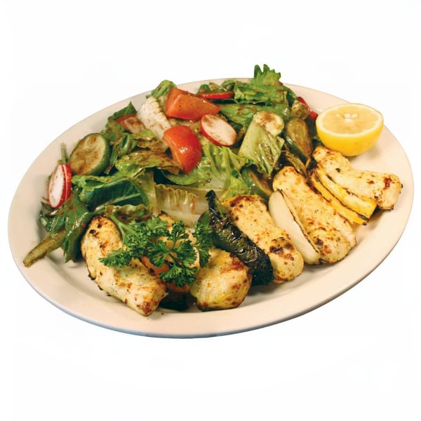Grilled chicken and vegetables with a side salad, garnished with parsley and a lemon half.
