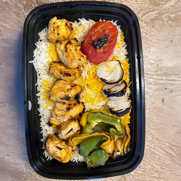 Caspian Mediterranean Grill's chicken kabob with rice, grilled tomato, onions, and bell peppers.